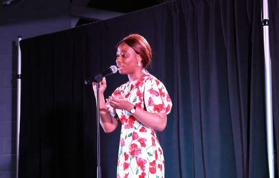 A contestant sings into a microphone on the SLC stage