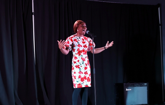A contestant sings into a microphone on the SLC stage