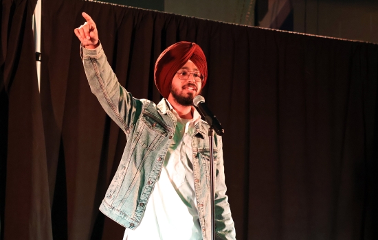 A contestant sings into a microphone on the SLC stage