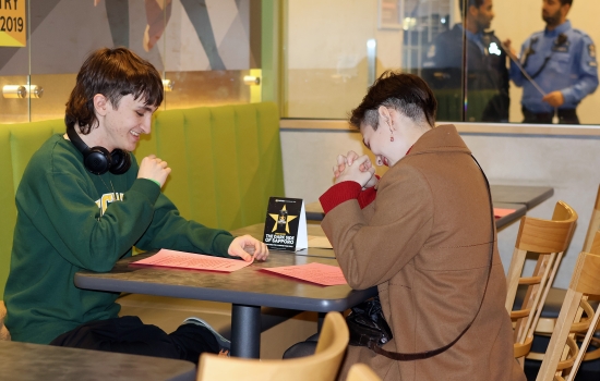 Two students laugh together as they try speed dating