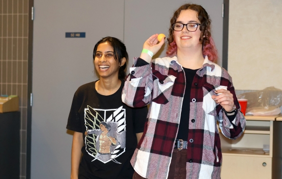 Two students smile while playing lemonade pong