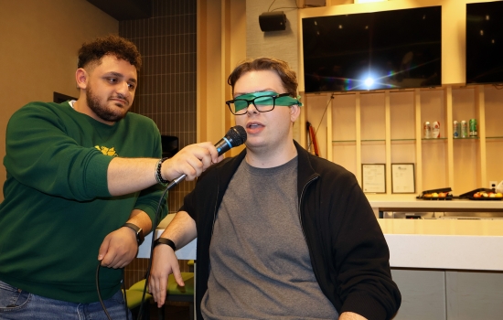 A student is blindfolded for UpDating as Ali holds a microphone for them