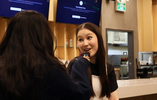A student smiles and speaks into the microphone during UpDating