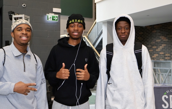Three students smile for the camera in the SLC