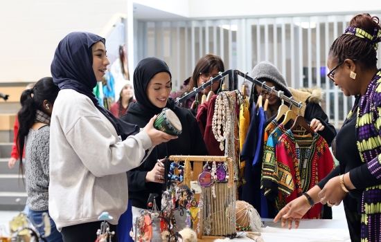 Students smile and chat with a vendor