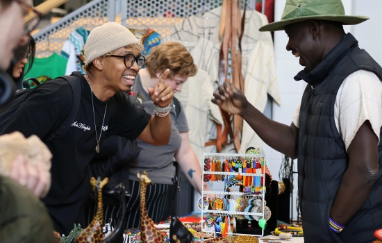 A student connects with a vendor as they share a laugh