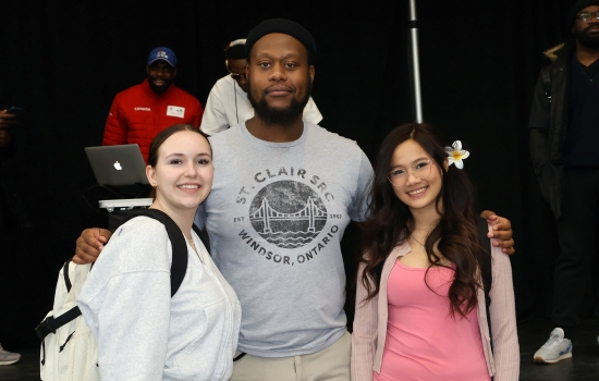 Two students pose with a student staff member
