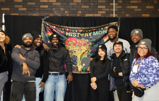 Students and student staff pose with the Black History Month banner