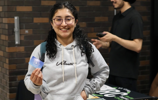 A student holds up a giftcard they were awarded