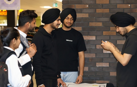 Pratham speaks with students at the table for his event
