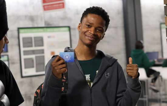 A student holds up a giftcard they were awarded