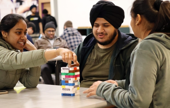A group of three students play Monopoly Jenga