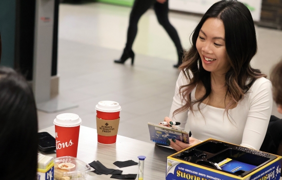 A student smiles while playing Telestrations with friends