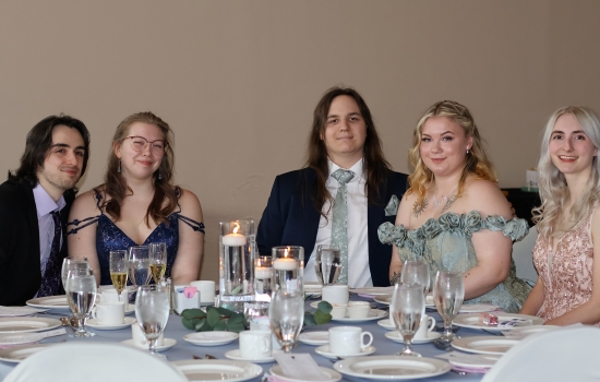 A table of guests pose for the camera