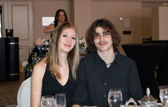 Two guests in their seats pose for the camera