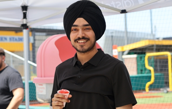 Pratham smiles while holding a snowcone