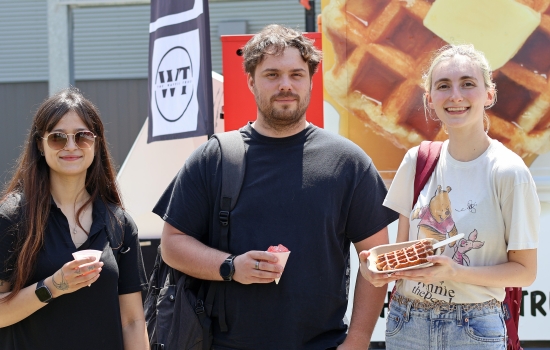 Three students pose with with snowcones and waffles