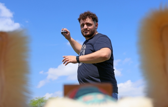 POV: Ali winds up to throw a beanbag at a carnival game