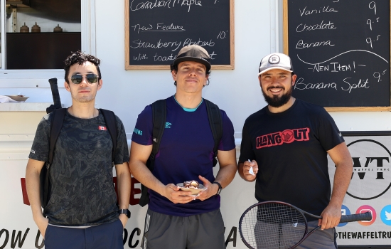 Three students pose in front of the waffle food truck