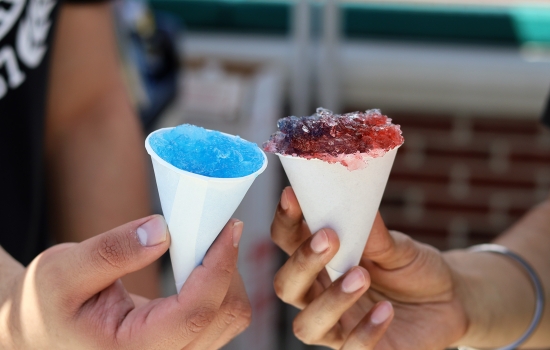 Board members hold up snowcones, one red and one blue