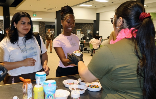 Nanza hands ice cream to a smiling student