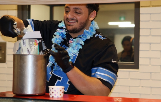 Ali smiles and scoops ice cream