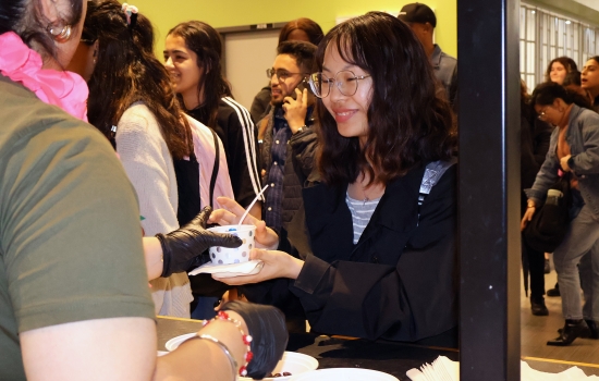 Nanza hands ice cream to a smiling student