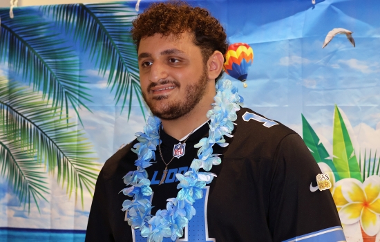 Ali poses in front of the backdrop