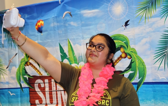 Nanza takes a polaroid selfie in front of the backdrop