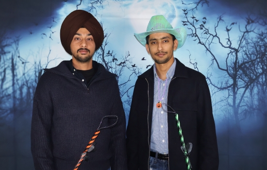 students hold brooms