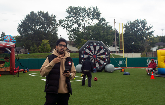 a student poses for a photo in front of the inflatable games