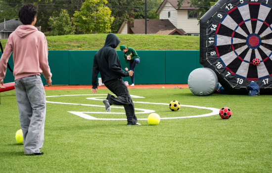 a student kicks a soccer ball at an inflatable target