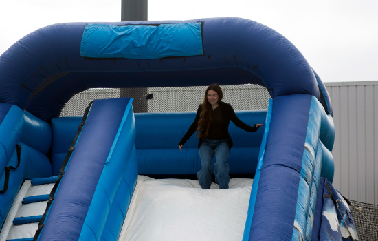 A student riding an inflatable slide