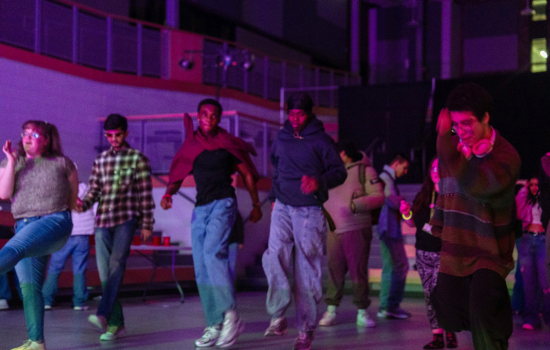 students dance in the slc