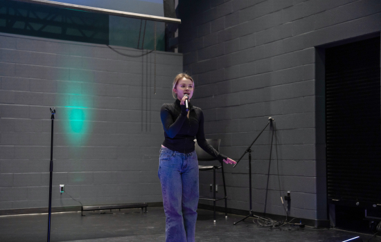 A contestant sings into the mic