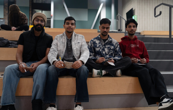 4 students smile for the camera while playing bingo 