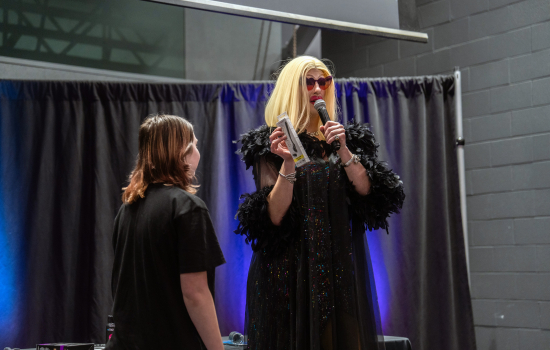 A student on stage with the drag queen host