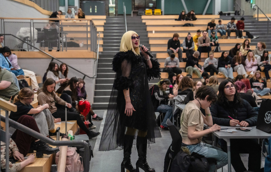 The host addresses the crowd in the SLC