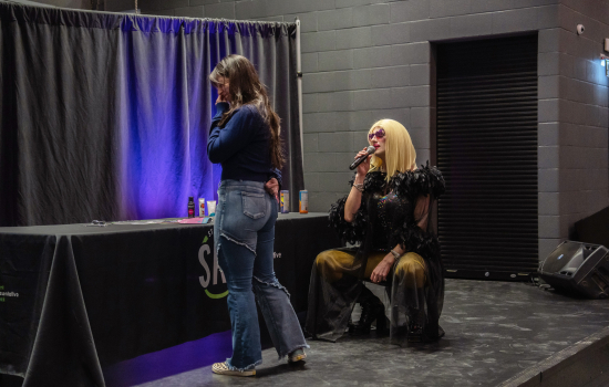 A student on stage with the drag queen host