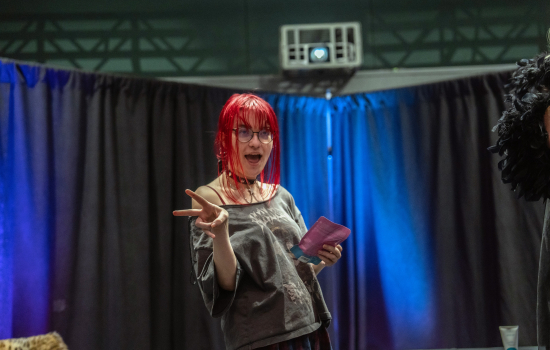 A student throws a peace sign while choosing their prize