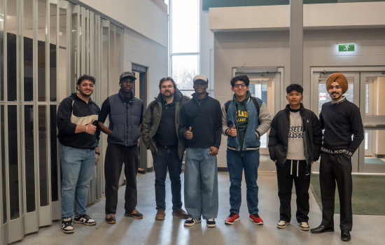The board poses for a photo with students in the SLC