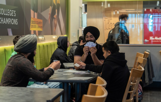 3 students enjoy a card game