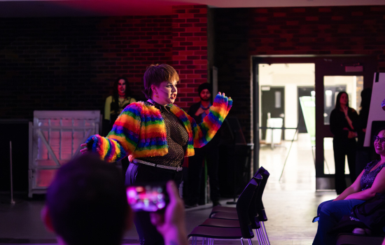 Drag king Hundson Bae performs in a rainbow jacket