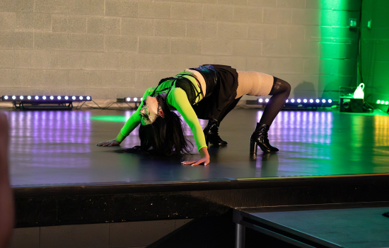 Drag queen Vyrus performs in green and black clubwear