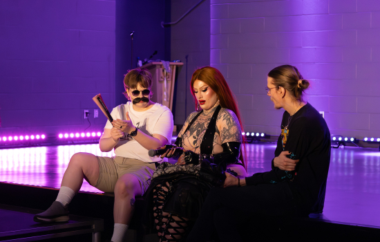 Hudson Bae and Angelina Lepore sit on the stage with a student