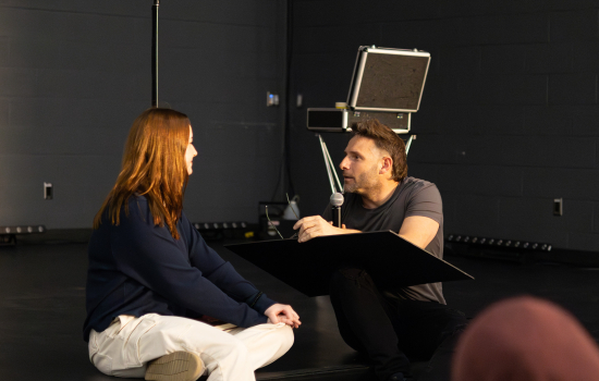 Eric Leclerc and a student volunteer seated on stage
