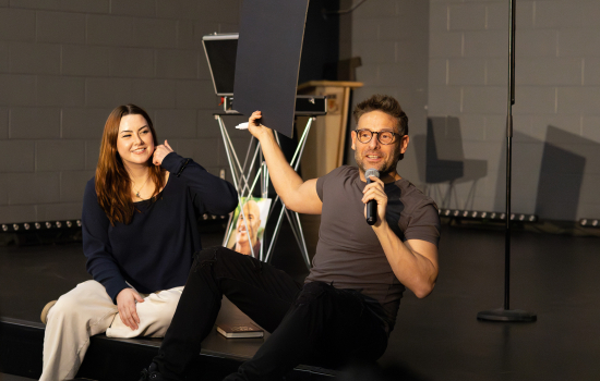 Eric Leclerc and a student volunteer seated on stage