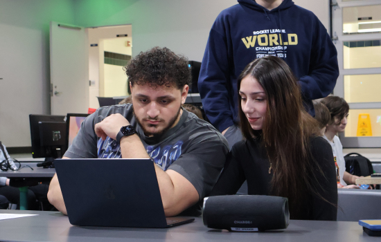 SRC board members look at a laptop together