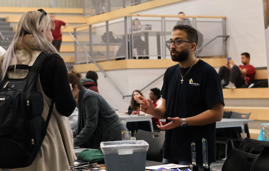 A club member speaks with a student