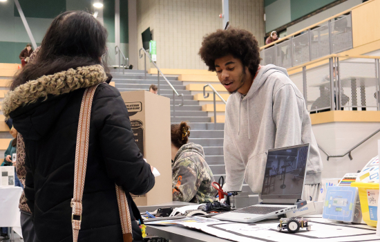 A club member speaks with a student